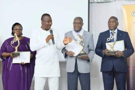 Le ministre en charge de l’Industrie, Harouna KABORÉ (micro) a décerné des prix spéciaux aux hommes d'affaires Simone Zoundi (à gauche), Lazare Soré et Lassiné Diawara (à droite) lors de la "Nuit du mérite".