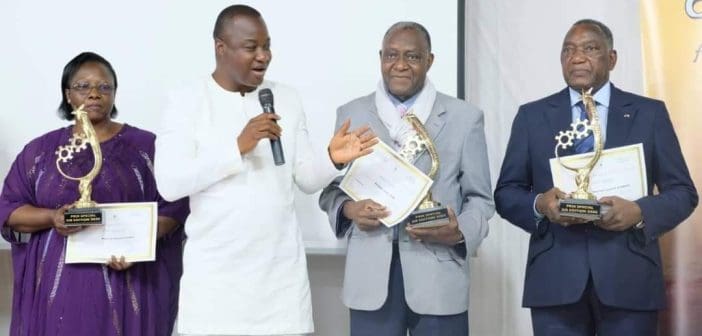 Le ministre en charge de l’Industrie, Harouna KABORÉ (micro) a décerné des prix spéciaux aux hommes d'affaires Simone Zoundi (à gauche), Lazare Soré et Lassiné Diawara (à droite) lors de la "Nuit du mérite".