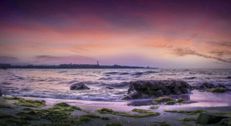 Photo d'une plage de Jersey au soleil couchant, illustrant le concept de géoparc