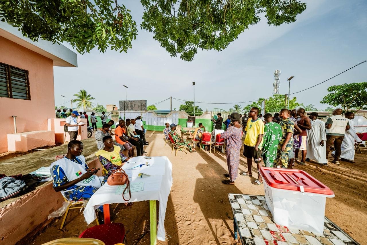 Bénin | Élections : affluence soutenue dès la mi-journée À Gogounou, dans le département de l’Alibori, les cours d’écoles ont connu leur plus forte affluence aux toutes premières heures de la matinée. Dans cette région septentrionale où le pastoralisme rythme le quotidien, l’objectif premier des habitants était de devancer la montée des températures. « Je suis venu m’aligner depuis 6h30. Avec le soleil qui frappe vite ici, il vaut mieux voter à la fraîche. Comme il n’y a pas d’activité au champ aujourd’hui, je vais juste rentrer m’occuper de mes bêtes à la maison », explique Orou, éleveur, l’index marqué par l’encre indélébile.